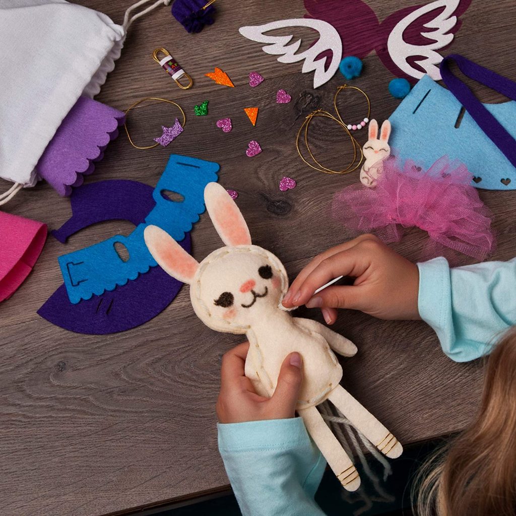 Child using DIY sewing kit to make a stuffed rabbit, helping build bilateral coordination