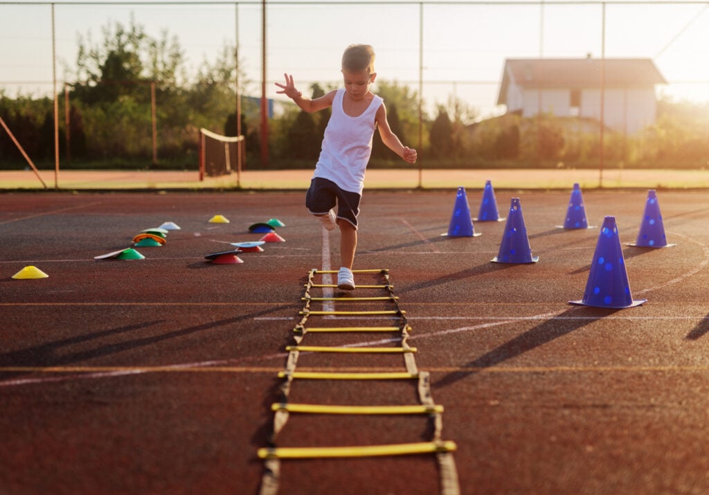 A child outside doing an obstacle course, an activity that can help build spatial awareness.