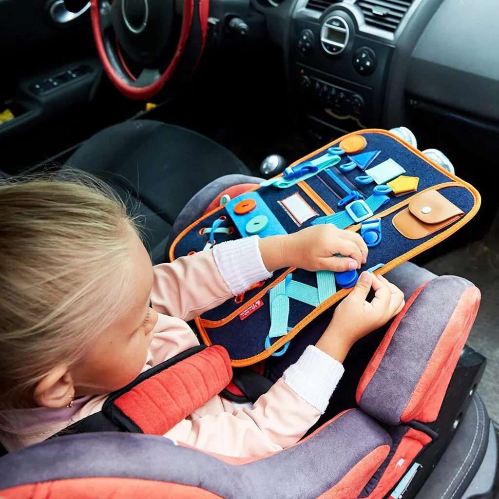 child in car using learning backpack to practice fine motor skills.